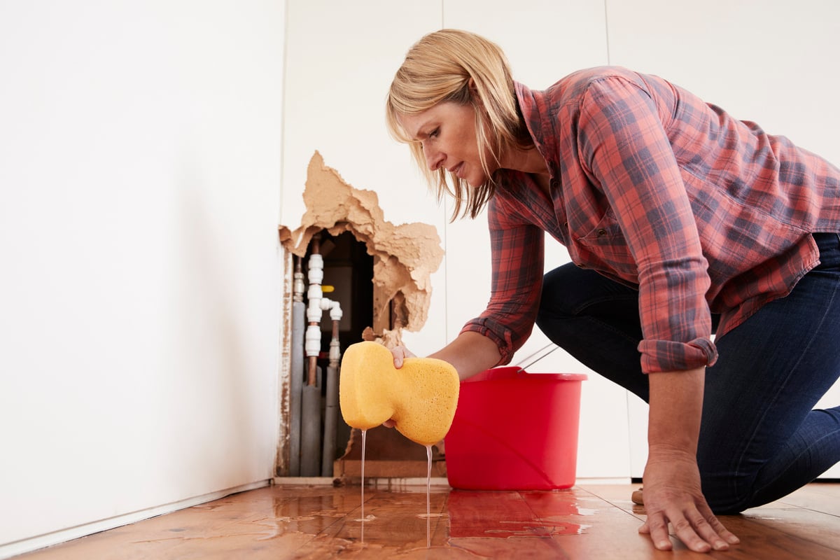 A woman cleaning up water damage in a home