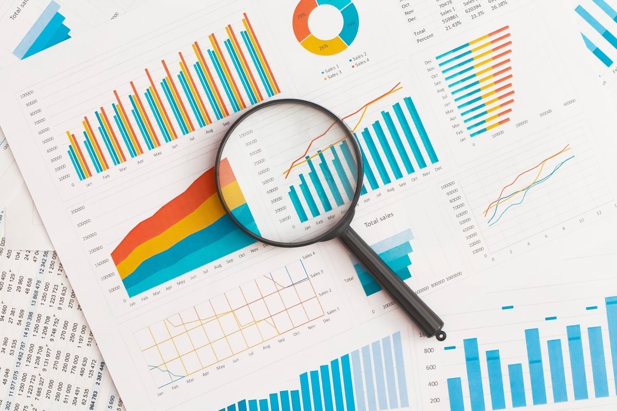 Graphs and data on paper and a magnifying glass