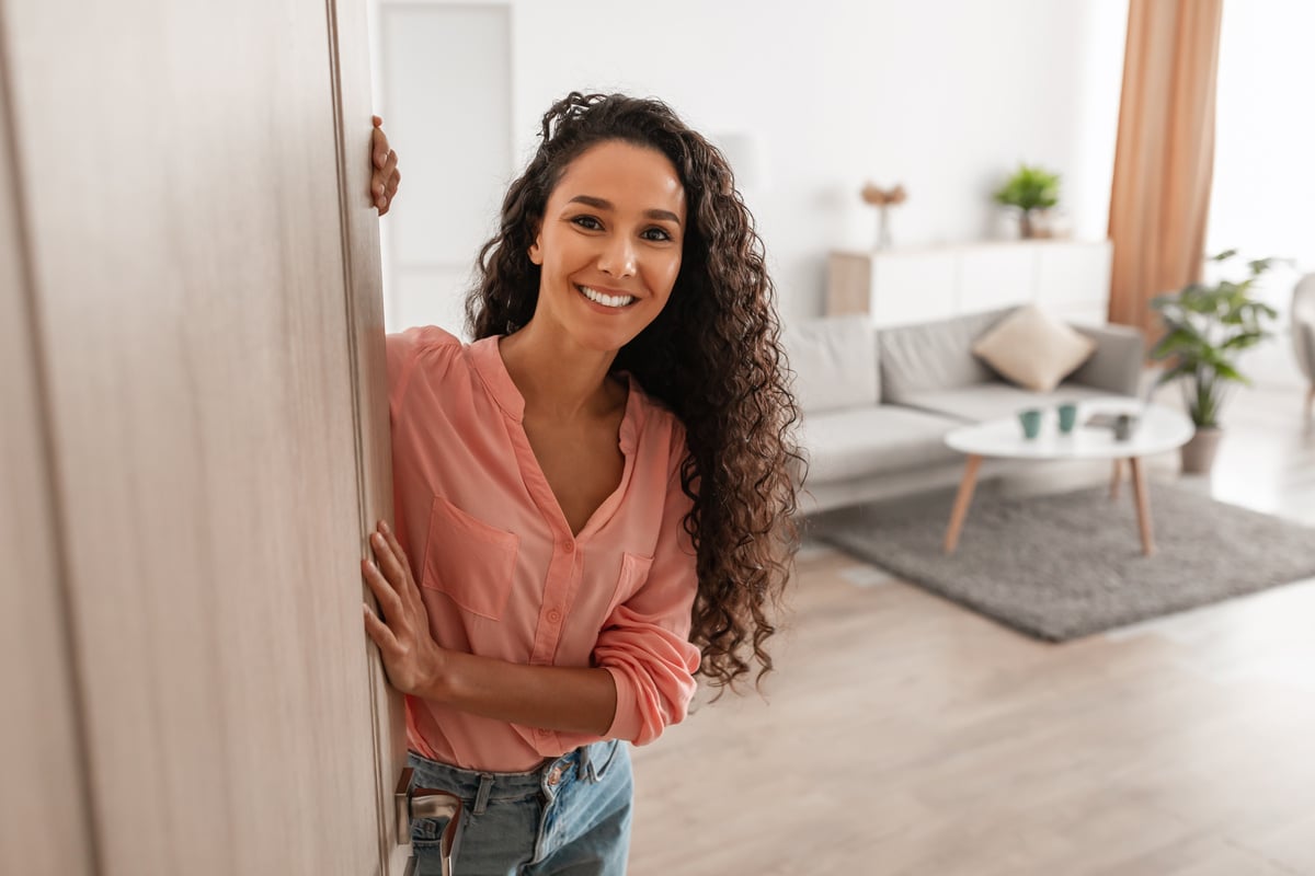 Happy tenant standing in doorway of new modern home