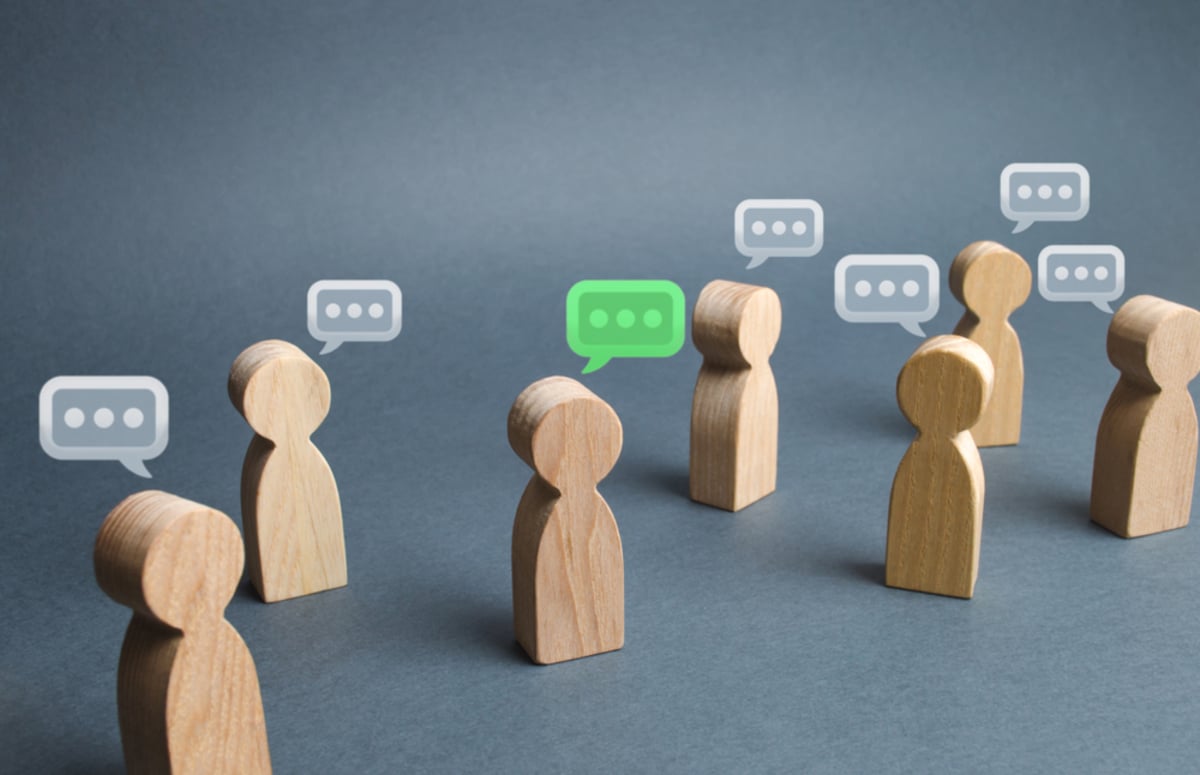 People wooden figures with comment clouds above their heads