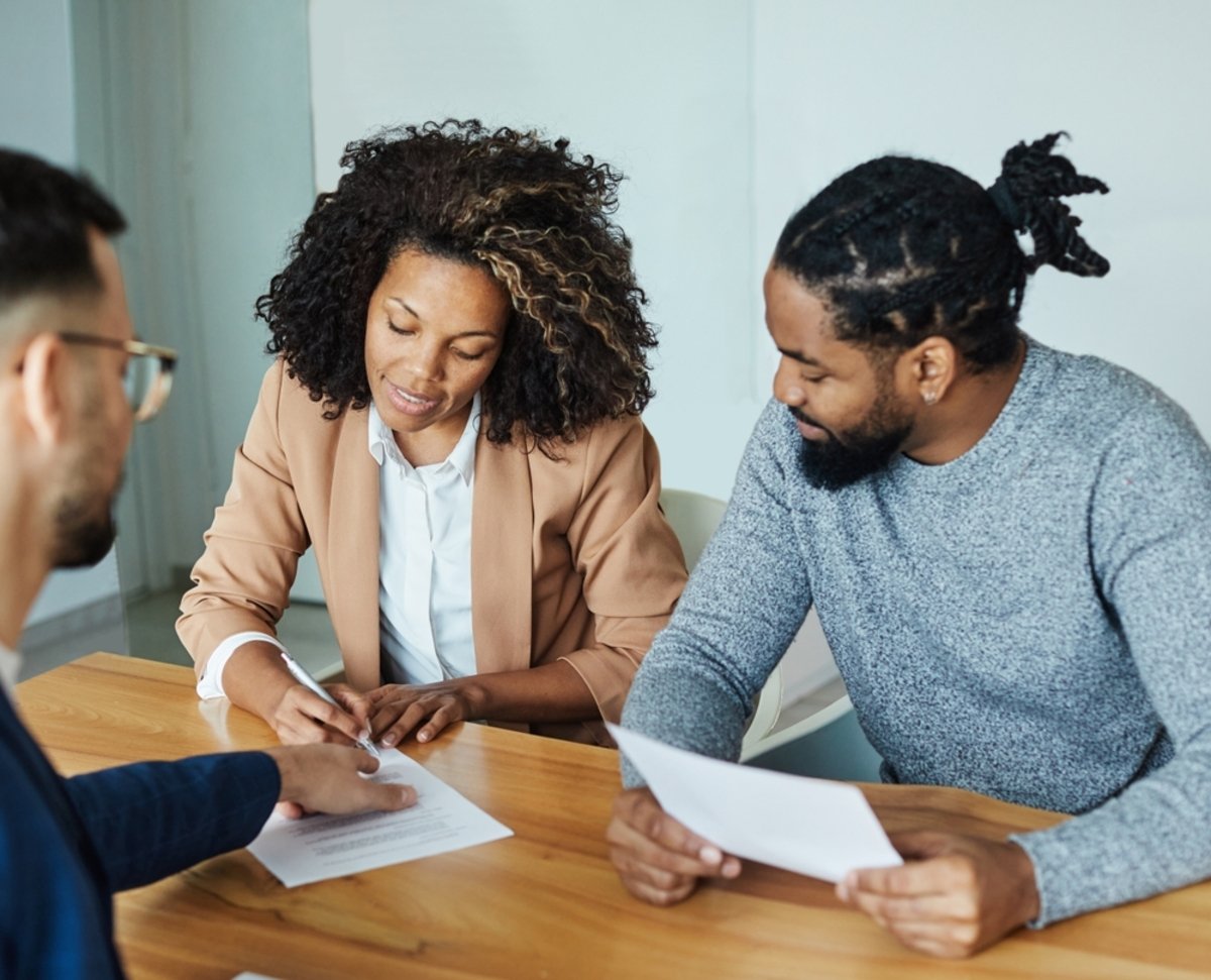 Property manager helping young couple navigate HOA regulations