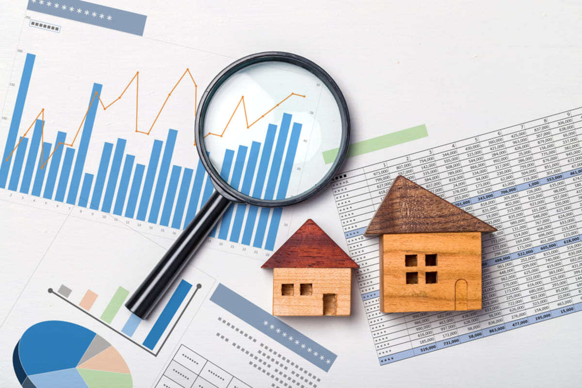 Wooden houses in front of graphs and data